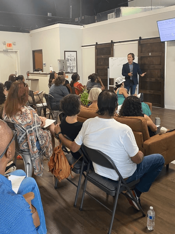 A member presenting to a full, seated room