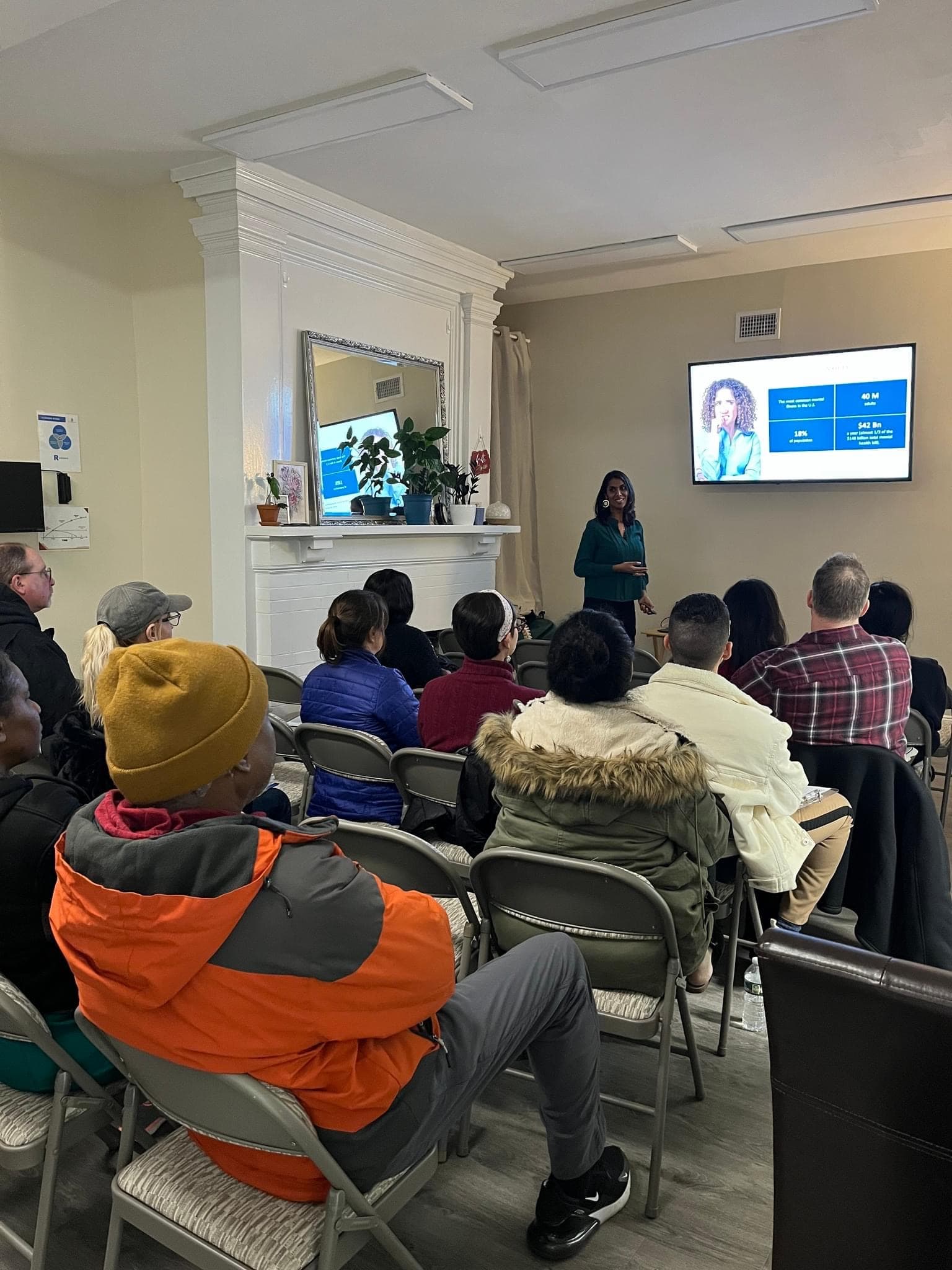 A member presenting to a full room, every chair taken