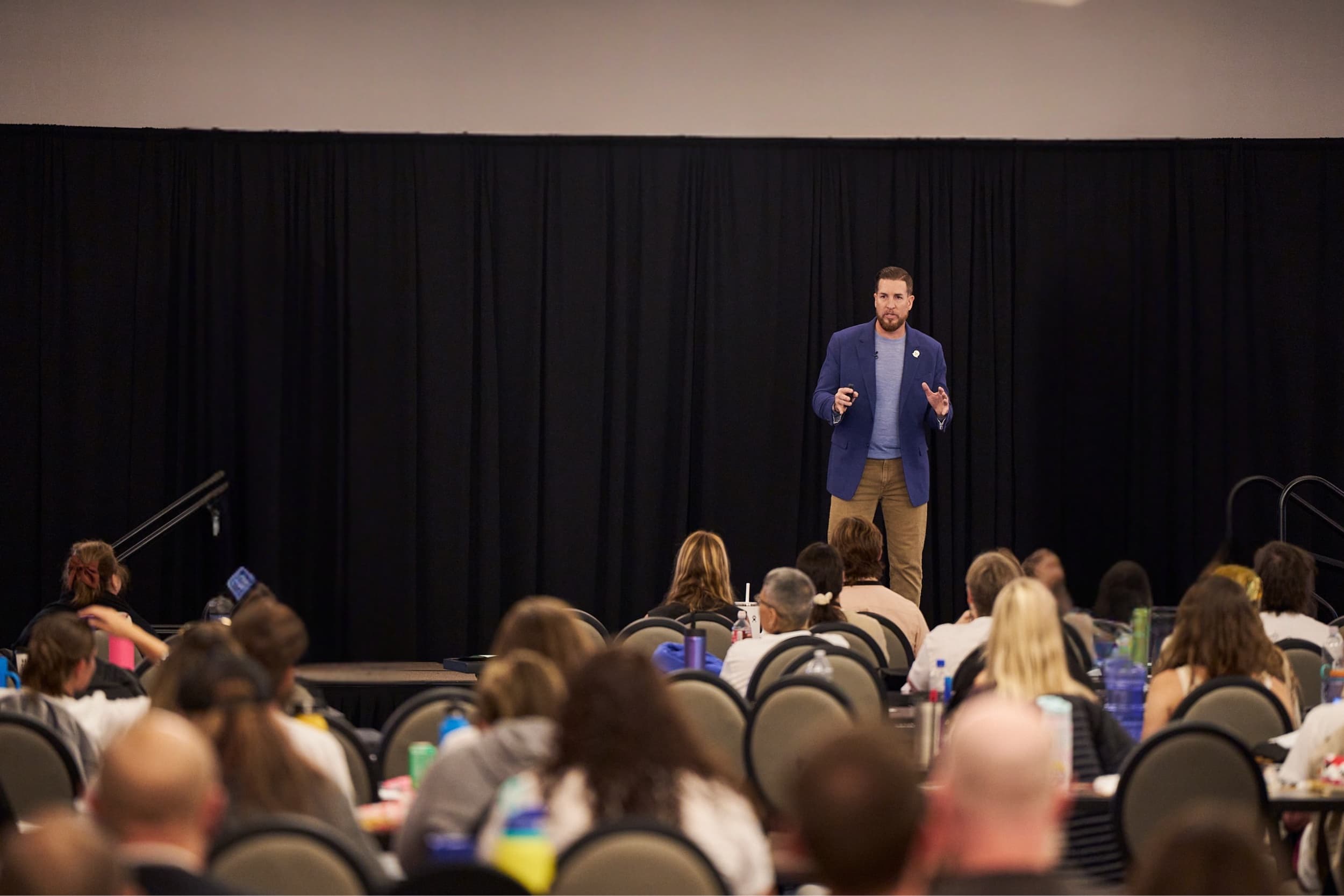 Dr. Steve Tullius speaking on stage to a full room of practitioners